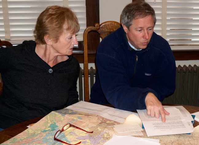 Researchers reading map and document
