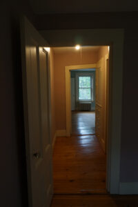 Hallway picture shows angle of doorframe versus relatively square window.