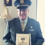 Jonathan Gray in uniform holding picture of his father