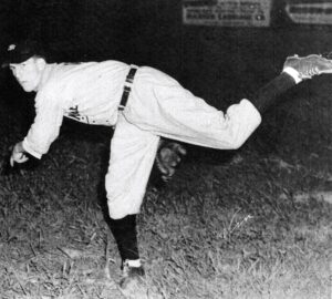 Vin Palumbo in baseball uniform pitching ball.