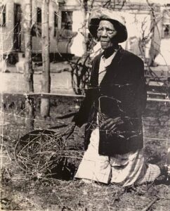 Black woman (Tinah) kneeling in garden