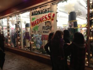 Storefront window of Lords for with Midnight Madness Sale sign in window