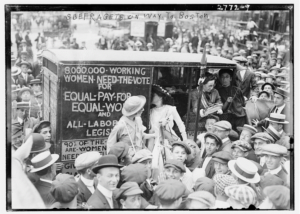 Crowd of men and women in hats with van