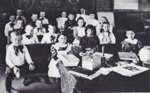 Young pupils sitting at desks in school room.