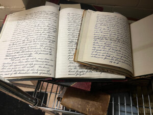 Handwritten journals on metal rack