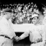 Two men in baseball uniforms shaking hands