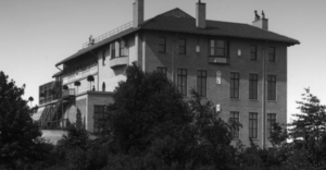 Large building with chimneys with trees in front