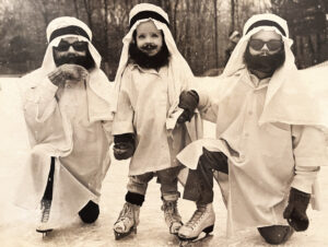 Three children dressed in costume on ice skates