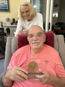 Peter and Anna Higgins with Peter holding anniversary medal