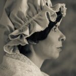 side profile of woman in colonial head covering