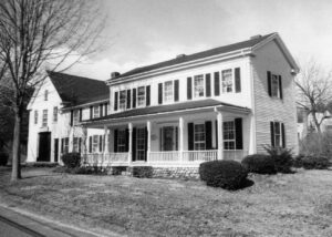 white house with large porch and black shutters